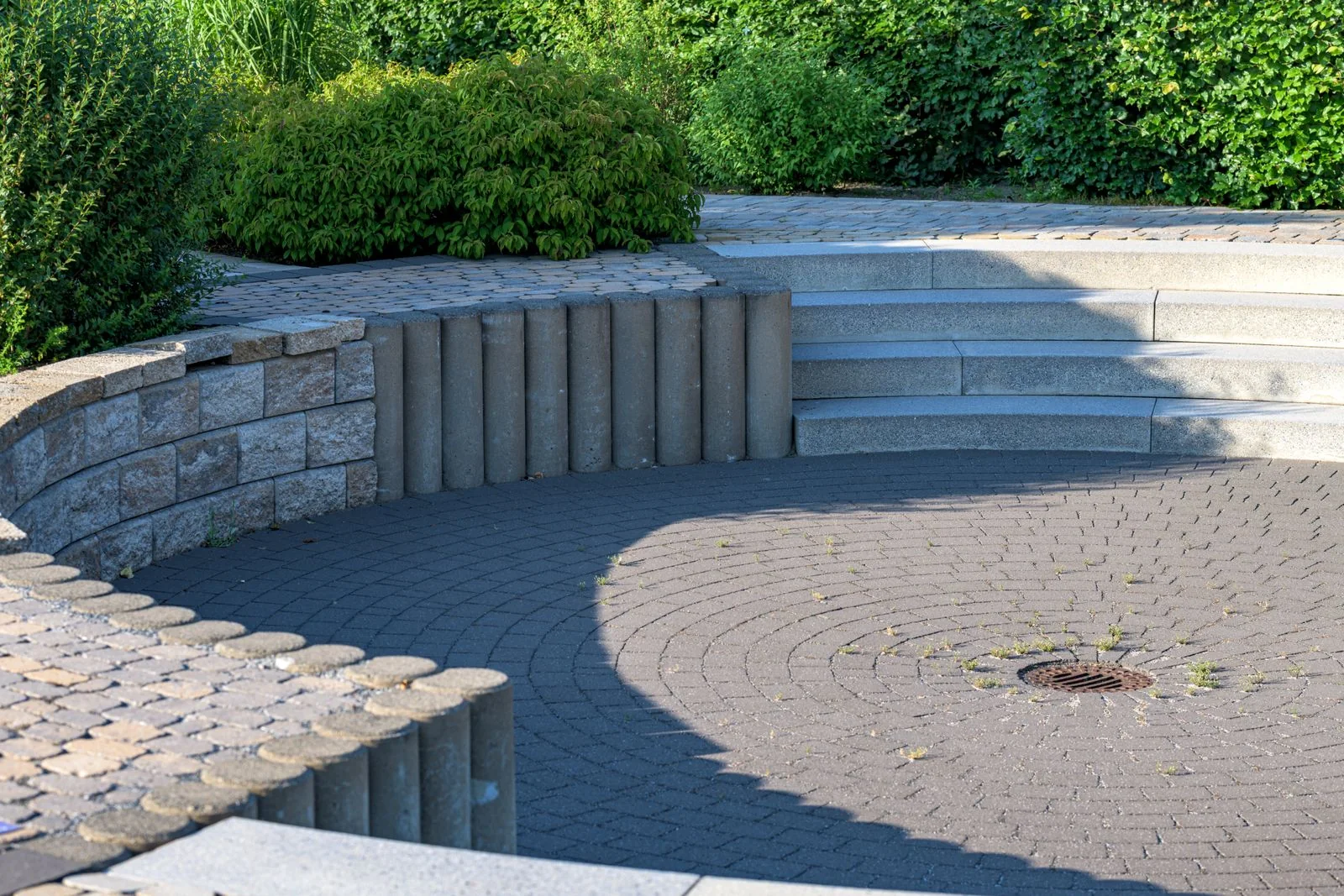 Curved stone terrace with integrated steps and planted borders